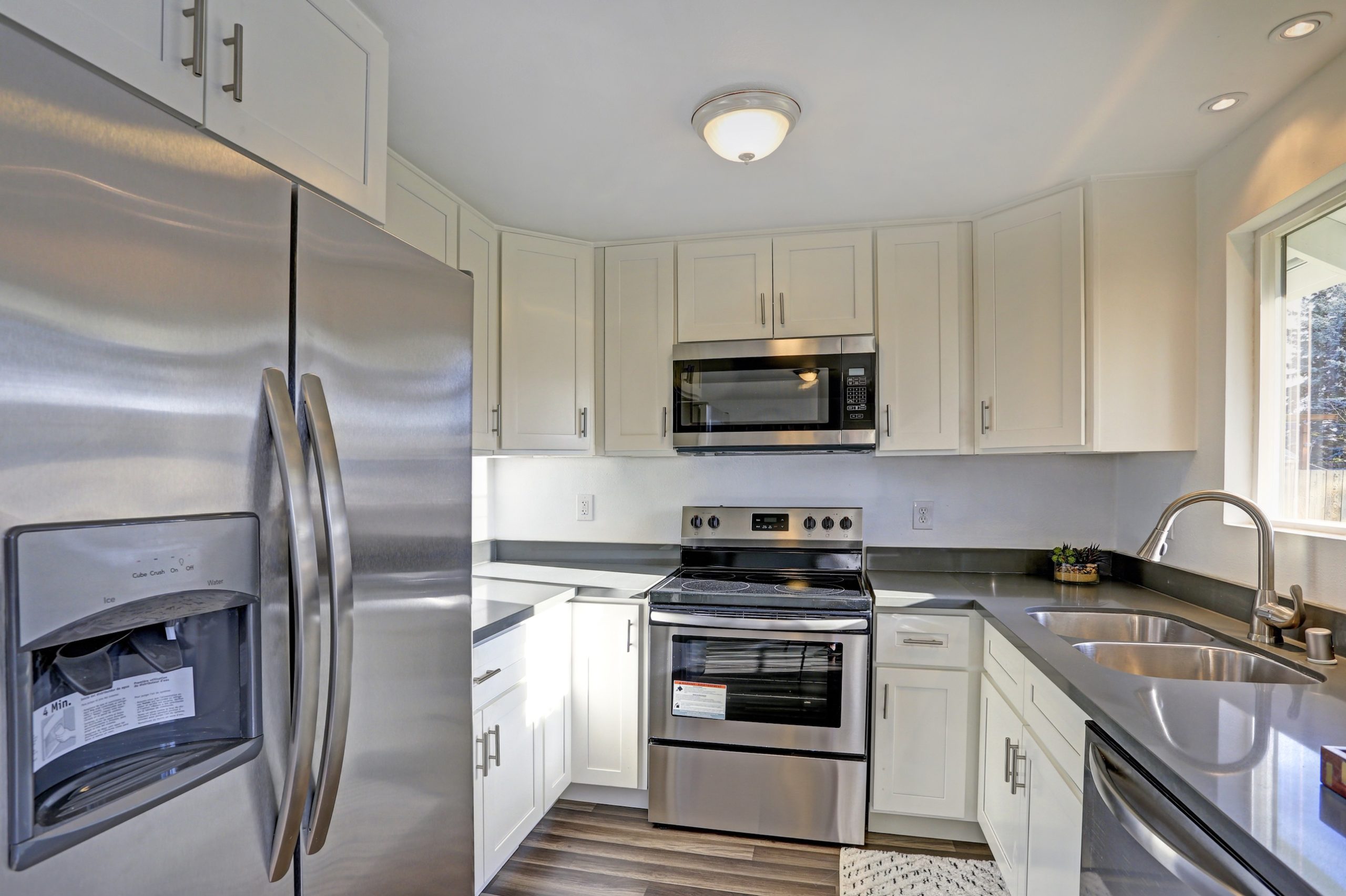 Modern kitchen with a built-in microwave above a range, plus refrigerator and dishwasher